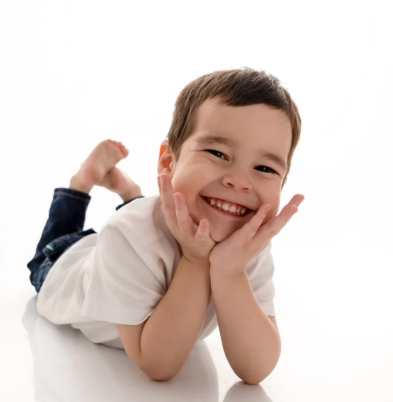 Niño con camiseta blanca y jeans sonriendo